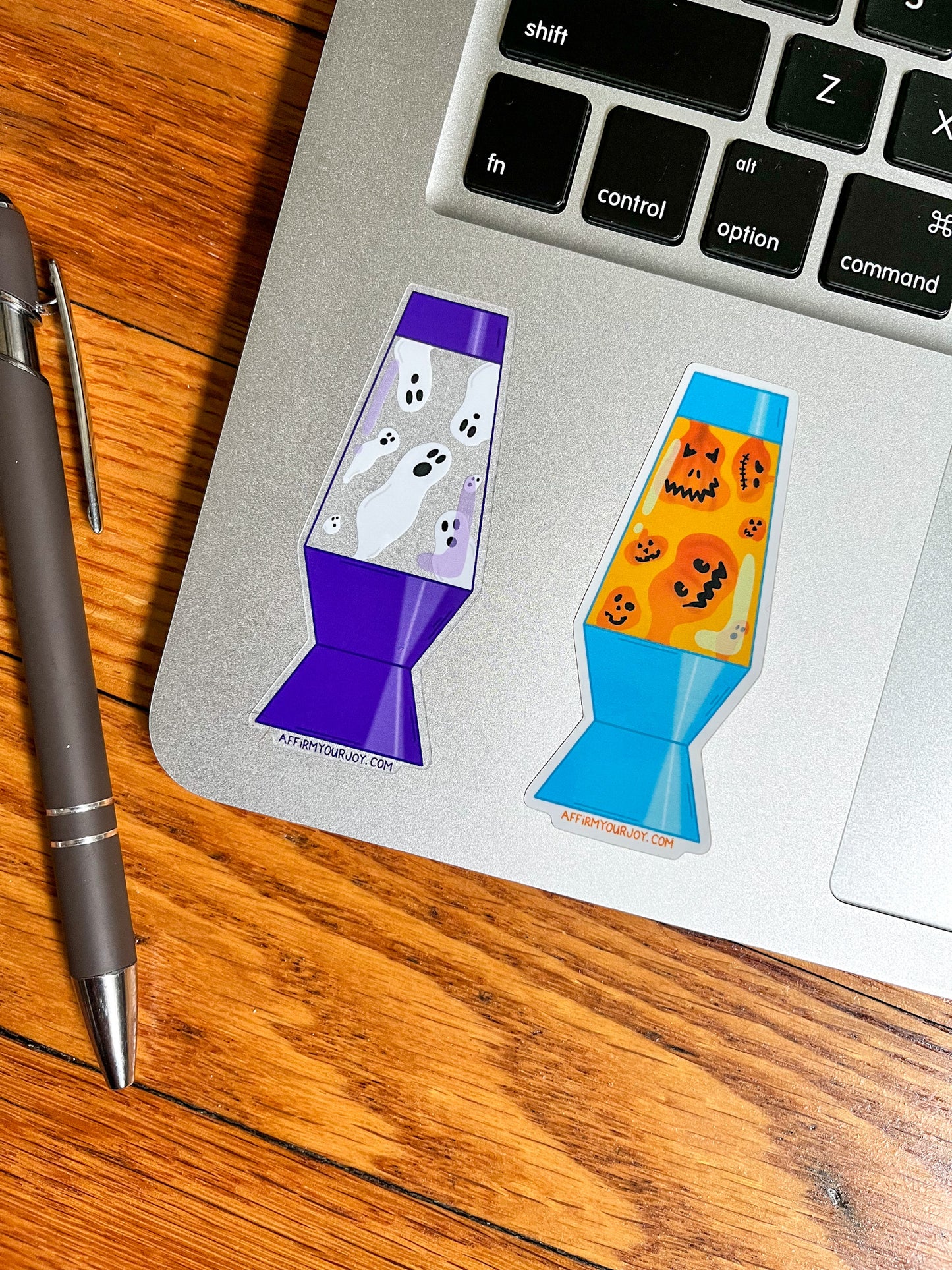 Pumpkin Lava Lamp and Ghost Lava Lamp stickers on a silver laptop