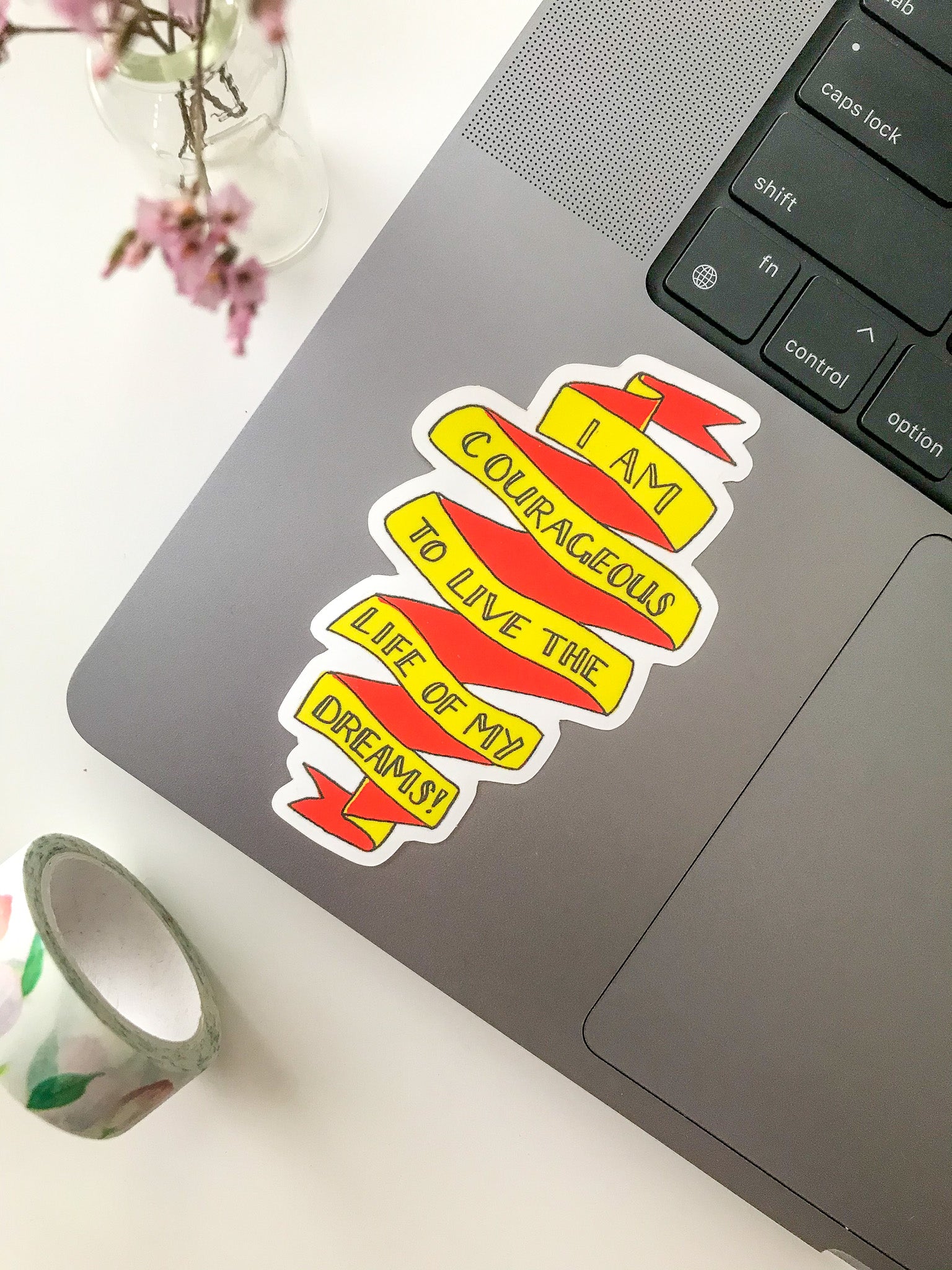 Yellow and red motivational sticker on laptop