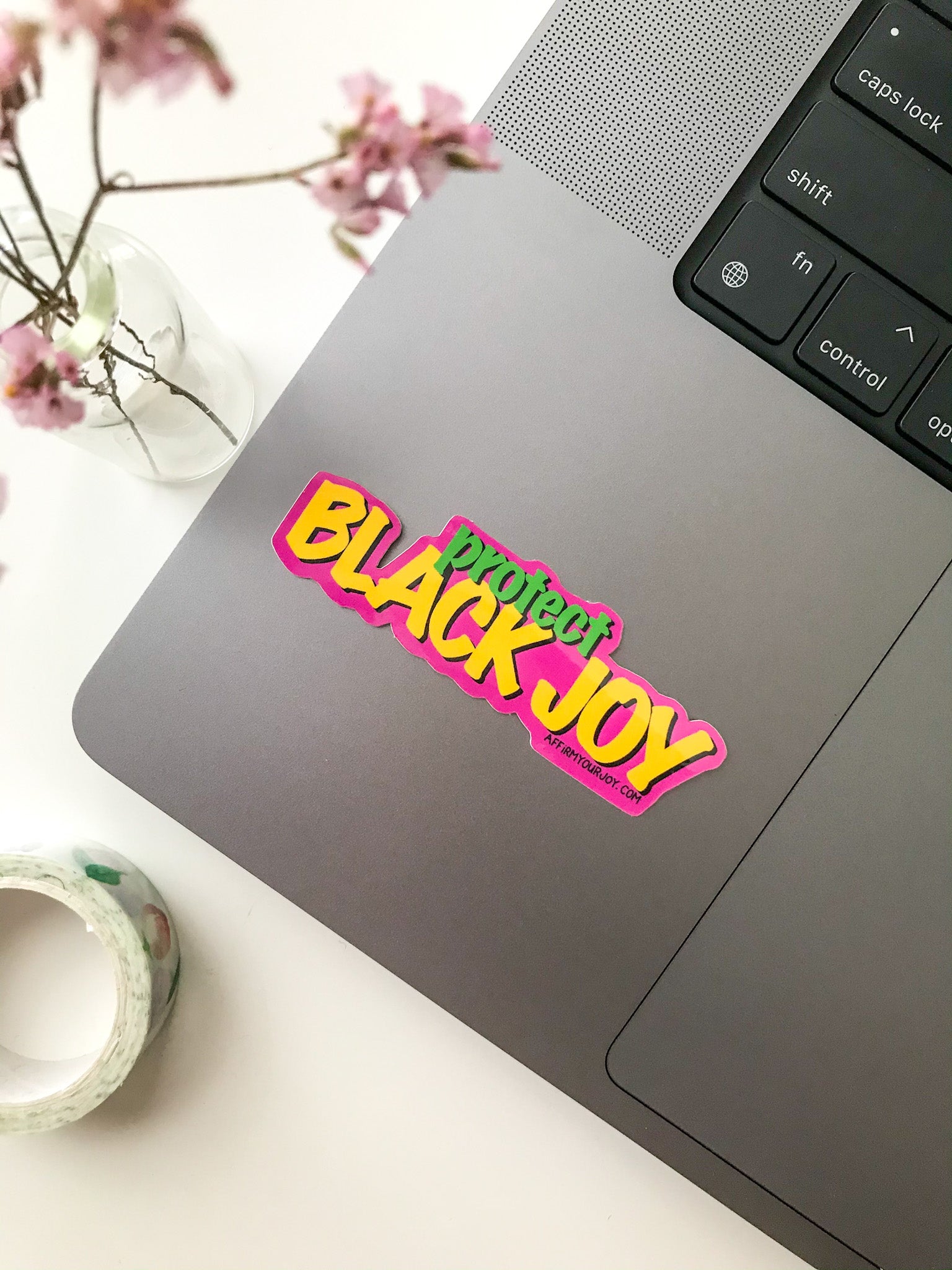 "Protect Black Joy" sticker on a laptop